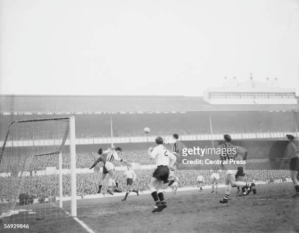 Tottenham Hotspur meet West Bromwich Albion at White Hart Lane, 28th December 1963. Spurs goalie Brown dives for the ball with Jones . Looking on are...