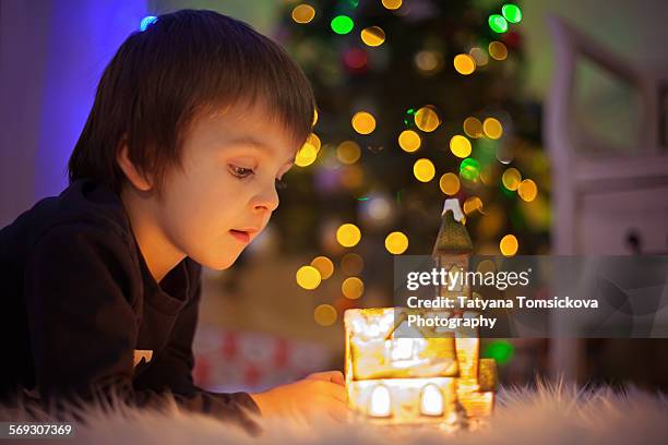 cute little boy, watching little lighted house - amber light stock pictures, royalty-free photos & images