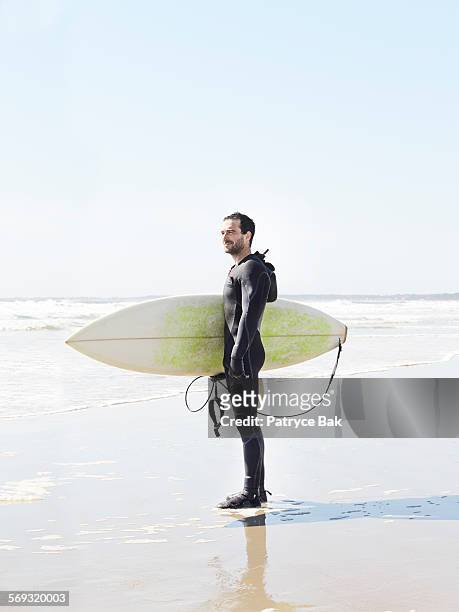 surf shop shaper returns from surfing in maine. - beach hold surfboard stock-fotos und bilder
