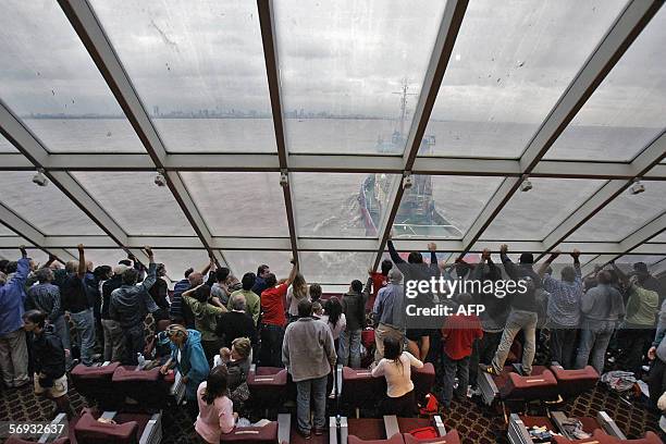 Buenos Aires, ARGENTINA: Pasajeros del buque "Eladia Isabel", de la empresa Buquebus, observan como la nave es remolcada hacia el puerto de Buenos...