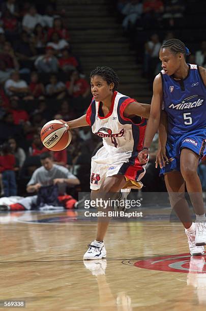 Anna DeForge of the Houston Comets drives past Elaine Powell of the Orlando Miracle during the WNBA game at Compaq Center in Houston, Texas on May...