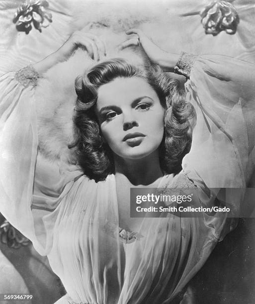 Judy Garland in a seductive pose, viewed from above on a bed, 1945.