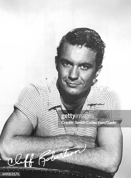 Portrait of Cliff Robertson smiling with folded arms, 1968.