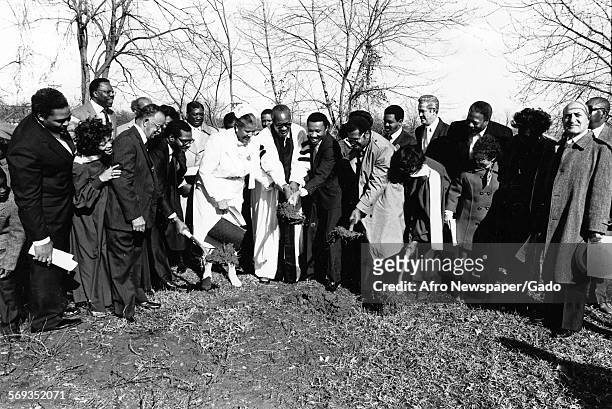Representative Kweisi Mfume and Councilman Nathaniel J McFadden gathering outside with a group of church goers including a priest, 1987.