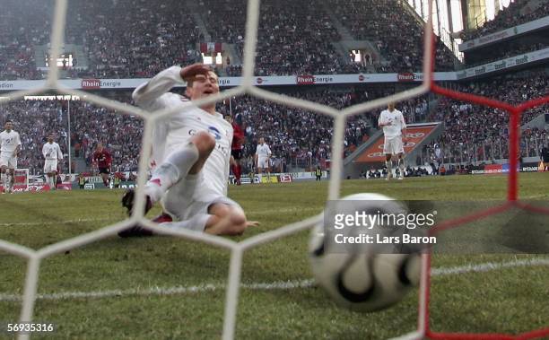 Lukas Sinkiewicz of Cologne slides behind the shoot of Andrej Voronin, who scores the second goal, during the Bundesliga match between 1. FC Cologne...