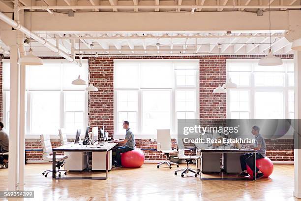 distant view of open plan office - yoga ball work stock pictures, royalty-free photos & images