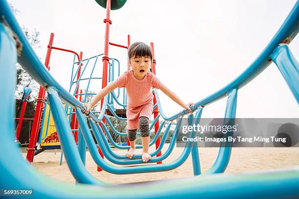 little girl playing with climbing equipment - parque infantil - fotografias e filmes do acervo