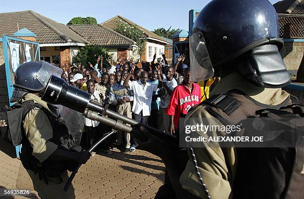 Ugandan police face supporters of opposition leader Kizza Besigye 25 February 2006 after dispersing them with live rounds and teargas outside his...