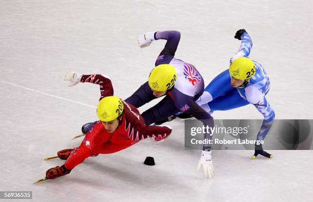 Eric Bedard of Canada, Jon Eley of Great Britain, and Roberto Serra of Italy skate in the men's 500 meter quarterfinals of Short Track Speed Skating...