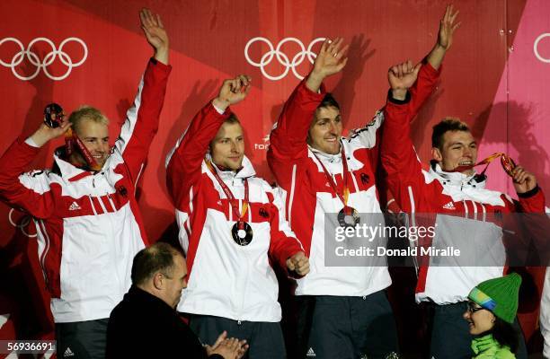 Pilot Andre Lange and teammates Rene Hoppe, Kevin Kuske and Martin Putze of Germany 1 celebrate their gold medal in the Four Man Bobsleigh Final on...