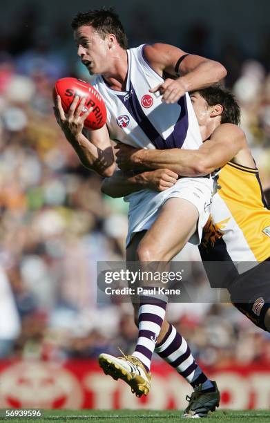 Steven Dodd of the Dockers attempts to handball ahead of Tyson Stenglein of the Eagles during the round one NAB Cup match between the West Coast...