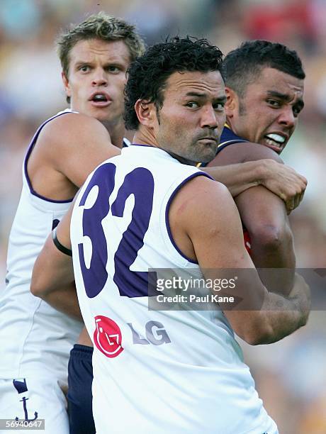 Dockers players Byron Schammer and Peter Bell and Daniel Kerr of the Eagles look back at the umpire during the round one NAB Cup match between the...