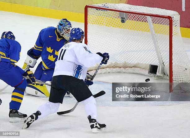 Saku Koivu of Finland skates past goalie Henrik Lundqvist of Sweden in the first period of the final of the men's ice hockey match between Finland...