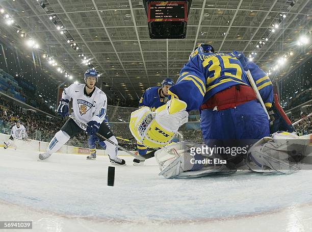 Saku Koivu of Finland watches as the puck slides past goalie Henrik Lundqvist of Sweden to take a 1-0 lead on a goal by Kimmo Timonen in the first...