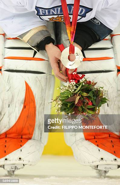 An unidentified Finnish silver medallist attends the podium ceremony after the 2006 Winter Olympic ice hockey gold medal game between Finland and...