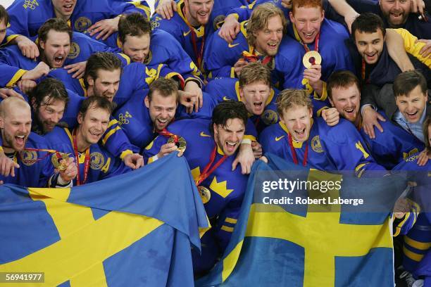 Team Sweden poses for photographers with their gold medals after defeating Finland 3-2 in the final of the men's ice hockey match between Finland and...