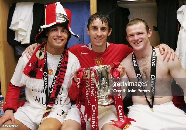 Cristiano Ronaldo, Gary Neville and Wayne Rooney of Manchester United pose with the Carling Cup trophy in the dressing room after the Carling Cup...