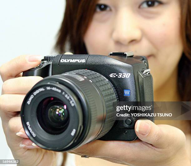 Japan's camera giant Olympus employee displays the new style SLR digital camera "E-330", equipped with a 7.5 mega-pixel Live MOS image sensor and the...