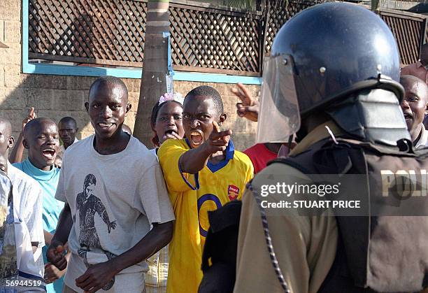 Ugandan police face supporters of opposition leader Kizza Besigye 25 February 2006 after dispersing them with live rounds and teargas outside his...