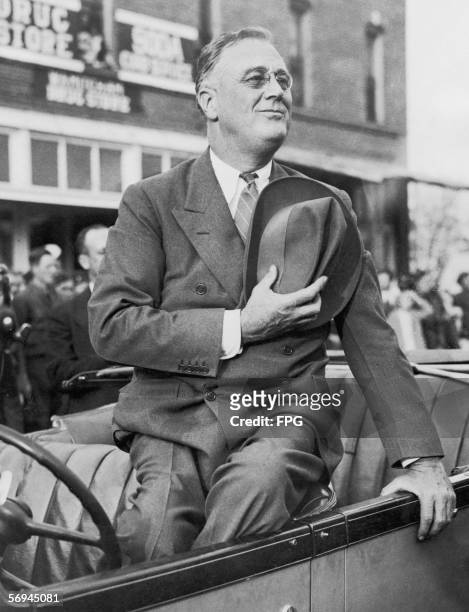 President Franklin D. Roosevelt salutes the flag during a parade, circa 1938.