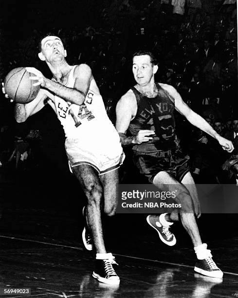 Bob Cousy of the Boston Celtics drives to the basket against Dick McGuire of the New York Knicks at the Boston Garden circa 1950 in Boston,...