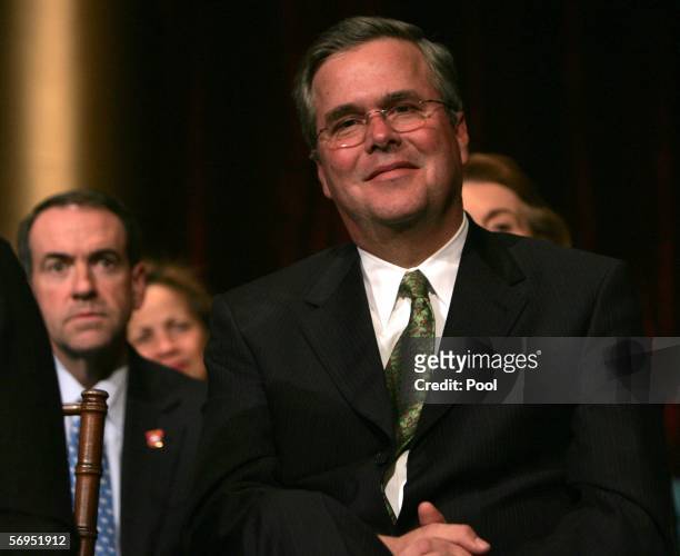 Governor Jeb Bush, Florida, listens to President George W. Bush speak as Governor Michael Huckabee, of Arkansas looks on during a dinner of the...
