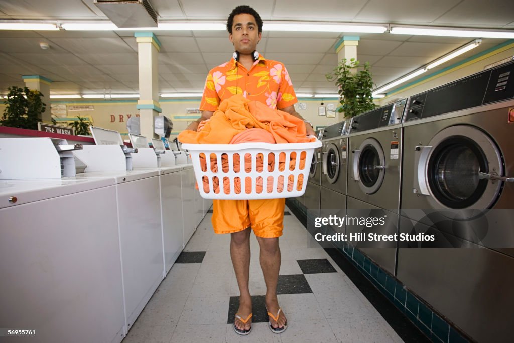Man standing in launderette with laundry