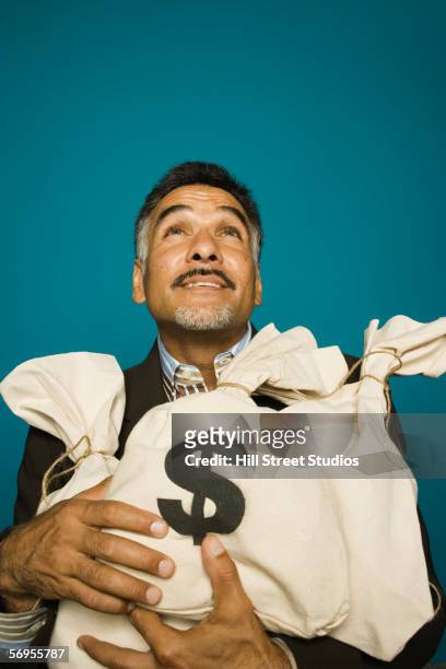 man holding bags of money - geldsack stock-fotos und bilder
