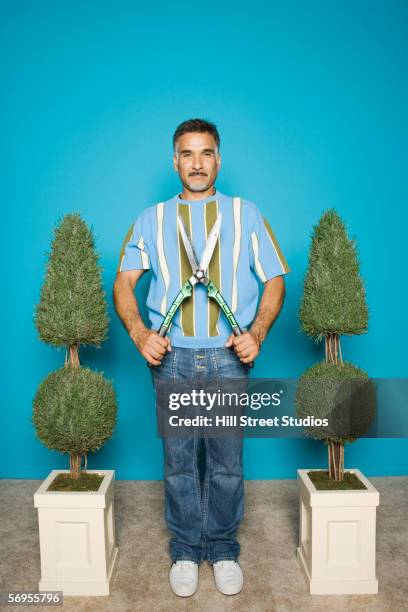 portrait of man with shrubs and hedge clippers - topiary stock-fotos und bilder