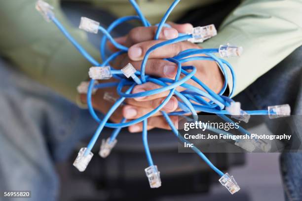 close-up of hands holding ethernet cables - bandwidth management stock pictures, royalty-free photos & images