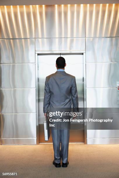 businessman waiting for elevator - open elevator stock pictures, royalty-free photos & images