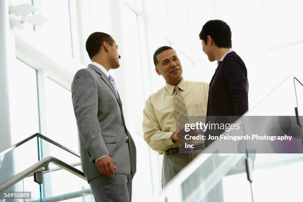 businessmen shaking hands with woman - blank expression stock-fotos und bilder