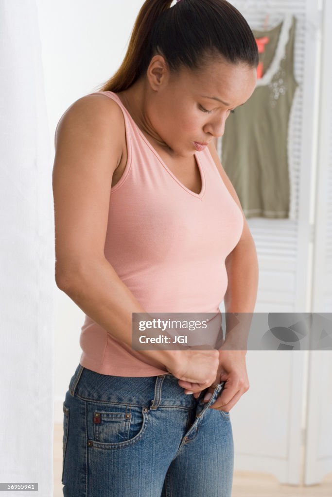 Woman buttoning her jeans