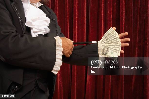 mid section of magician with money up sleeve - magic trick stock pictures, royalty-free photos & images