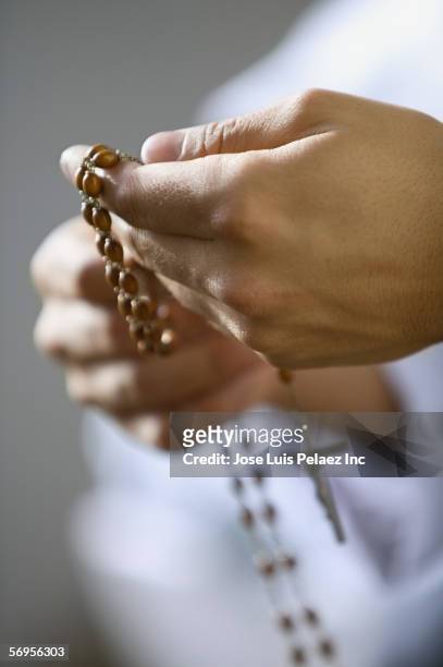 close up of hands holding rosary - rosary beads stock pictures, royalty-free photos & images