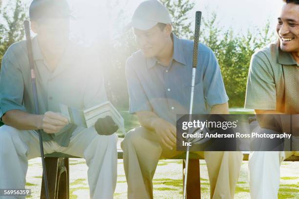 golfers looking at paper - luxury club stock pictures, royalty-free photos & images