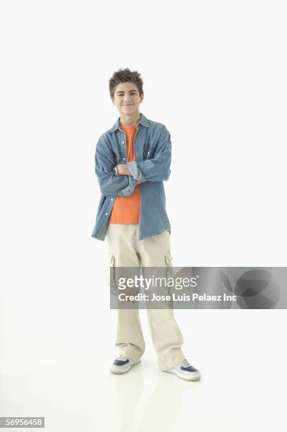 portrait of teenage boy standing with arms crossed - boys foto e immagini stock