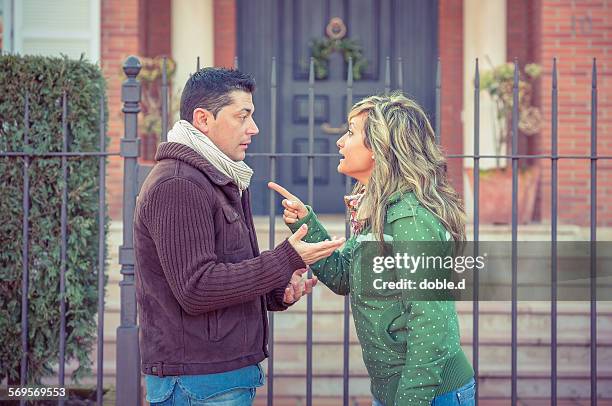 couple having argument in a hard quarrel outdoors - debate fotografías e imágenes de stock