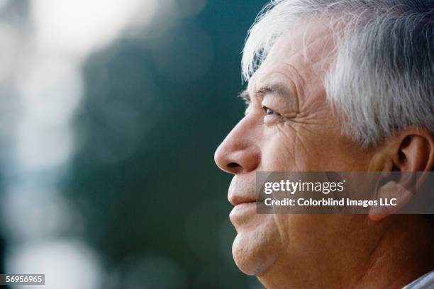 close up profile of elderly man - hispanic senior face stock-fotos und bilder