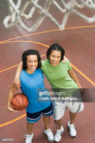 high angle portrait of two teenage girls playing basketball - alleen tienermeisjes stockfoto's en -beelden