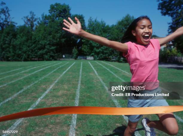 girl running through finish line at track - live finale stock pictures, royalty-free photos & images