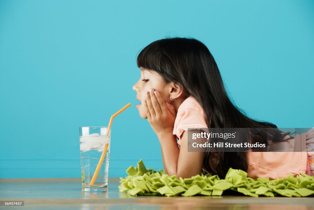 Girl lying on stomach sipping water