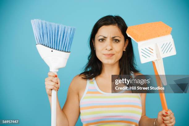 young woman holding mop and broom - woman sweeping stock pictures, royalty-free photos & images