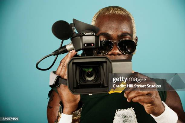 young man holding video camera - filmregisseur stock-fotos und bilder