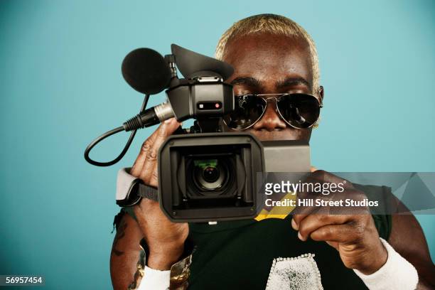 young man holding video camera - film director stock pictures, royalty-free photos & images