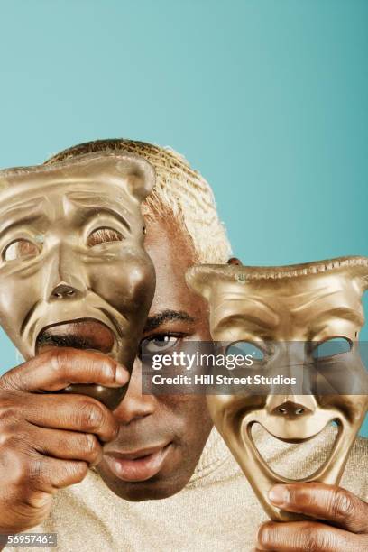 young man holding greek drama masks - comedy mask stock pictures, royalty-free photos & images