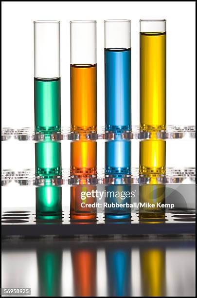 close-up of four test tubes on a test tube rack - reageerbuisrek stockfoto's en -beelden