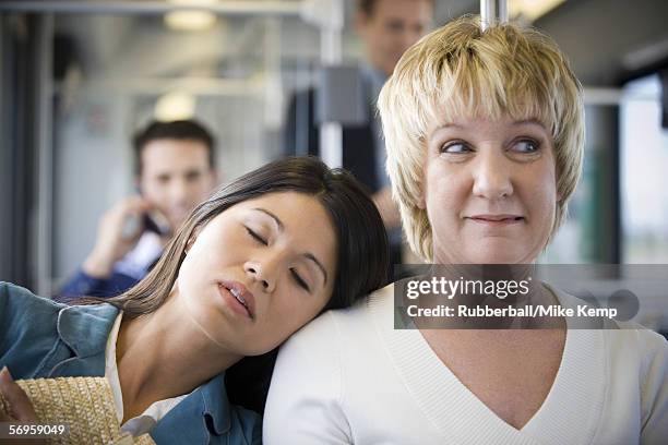 close-up of a young woman sleeping on a mature woman's shoulder - inconveniência imagens e fotografias de stock