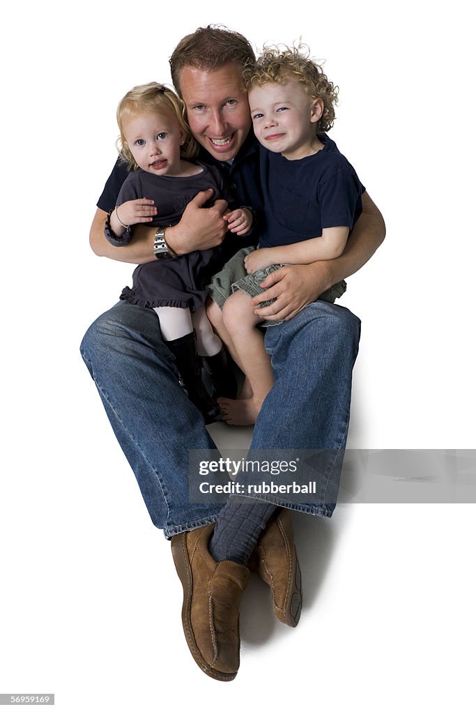Portrait of a father holding his two daughters