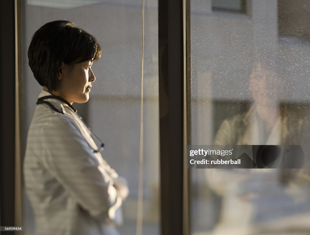 Profile of a female doctor looking through a window